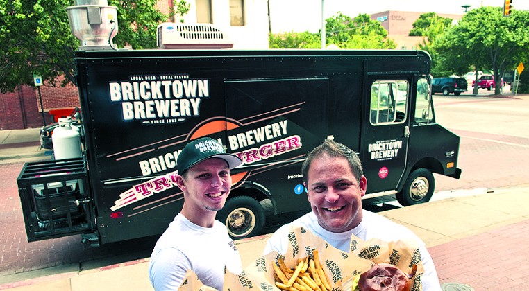 Left, Ryan Reynolds and Blake Lippert with hotdogs, fries and Burgers, surved by the Truckburger truck, parked behind them in Bricktown. (Mark Hancock)